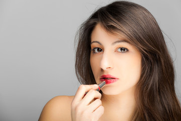 Gorgeous woman applying lipstick