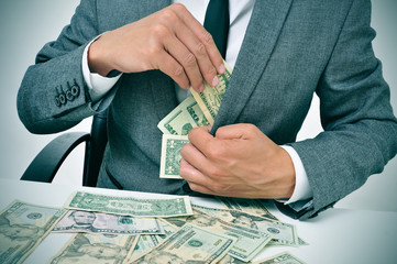 man in suit getting dollar bills in his jacket