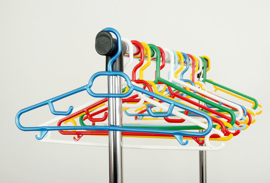 Closeup on a rack of clothes with colorful empty plastic hangers