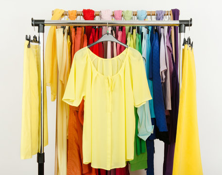  Cute yellow blouse and skirts displayed on a rack.