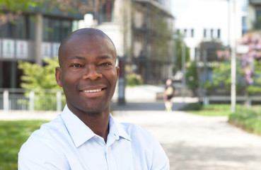 African man outside laughing at camera