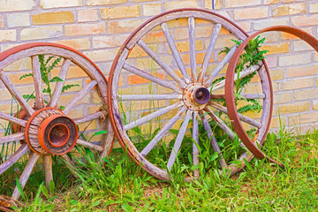 Abandoned faded wooden cart wheels together
