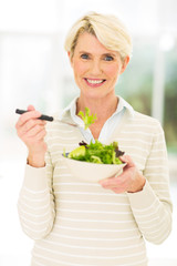 middle aged woman eating salad