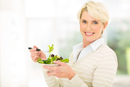 mature woman having green salad