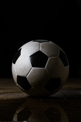 Fototapeta premium Isolated dirty soccer ball on black bavkground