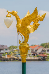 Closeup golden swan lamp on communities waterfront home.