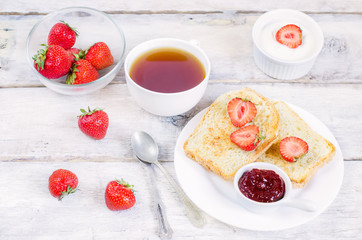 breakfast with fresh toasts, strawberries and strawberry jam