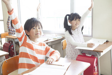 手をあげる小学生