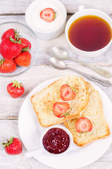 breakfast with fresh toasts, strawberries and strawberry jam