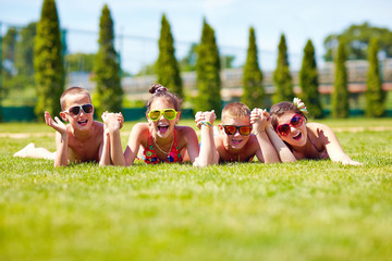 happy teenage friends lying on summer lawn