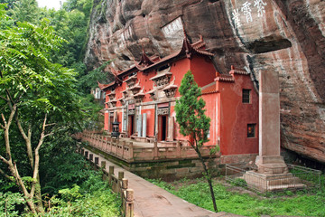 Temple building leaning against a vertical rock in Qiyun Taoist