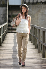 Beautiful brunette young woman outdoor with hat on