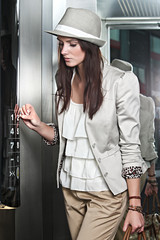 Beautiful brunette young woman with hat on using elevator
