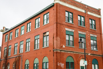 Fototapeta na wymiar Old Brick Building with Green Windows
