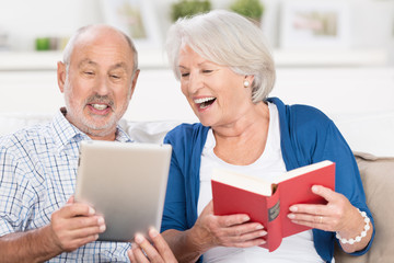 glückliches älteres paar mit tablet und buch