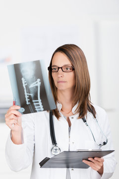 chirurgin schaut auf röntgenbild
