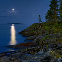 Obraz premium Moonlit night at stony shore of Ladoga lake