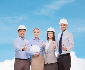 happy business team in office showing thumbs up