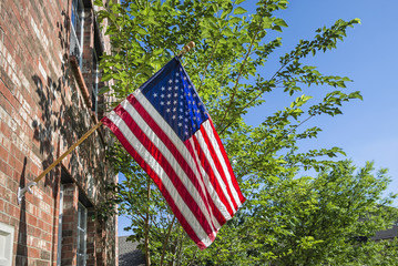 American flag in front of a brick home