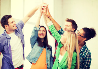 happy students giving high five at school