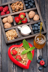 Granola muesli with berries, honey, nuts and milk.