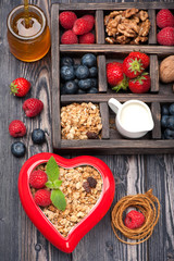 Granola muesli with berries, honey, nuts and milk.