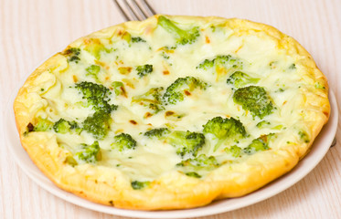 omelet with cheese and broccoli on a white plate