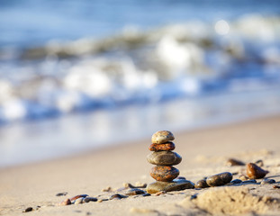 Stones pyramid on sand symbolizing peace and harmony.