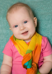 Baby girl in a pink t-shirt on green