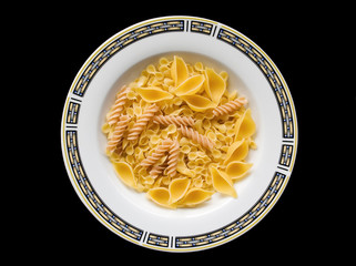 Pasta, plate with an ornament on a black background