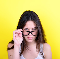 Portrait of strict young woman against yellow background