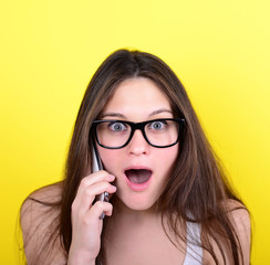 Portrait of young female in shock while talking on phone having