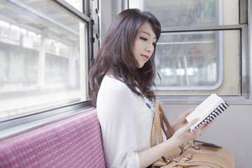 電車で本を読む女性