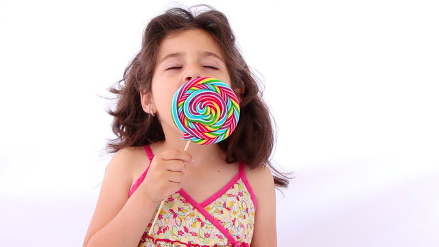 Little girl licking a lollipop, close up