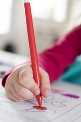 Close-up of hand child drawing with pencil at home