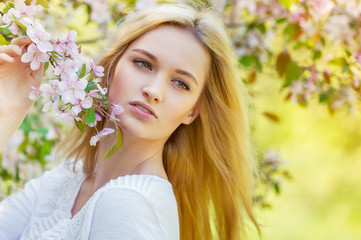 Obraz na płótnie Canvas Beautiful girl in spring apple tree blossoms