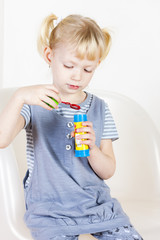 little girl playing with a bubbles maker