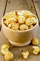 Popcorn caramel in wooden bowl on board