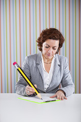 Businesswoman writing with a giant pencil