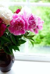 vase with colorful peonies on window-sill