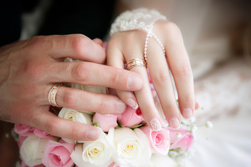 Hands of the groom and the bride with wedding rings