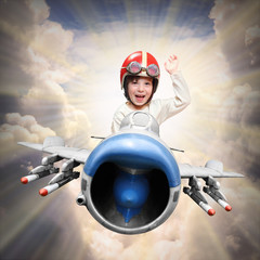 Happy little pilot flying in retro jet fighter. © Kletr