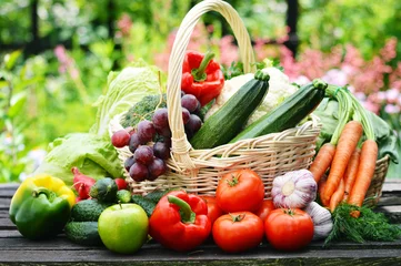 Tableaux sur verre Légumes Légumes biologiques frais dans un panier en osier dans le jardin