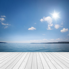 Landschaft mit Holz und See / Meer im Hintergrund