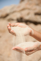 sand flows through the female hands