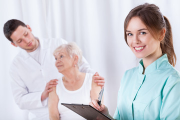 Fototapeta premium Elderly woman with doctors during rehabilitation