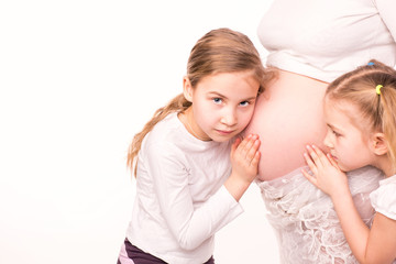 Happy children holding belly of pregnant woman