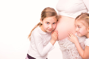 Happy children holding belly of pregnant woman