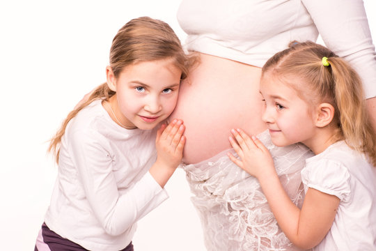 Happy children holding belly of pregnant woman