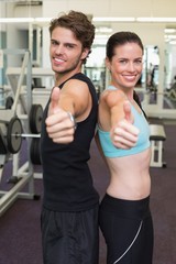 Fototapeta premium Fit attractive couple giving thumbs up to camera